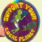 Holographic sticker with cartoon character holding Earth and text 'Support Your Local Planet' on a beige background