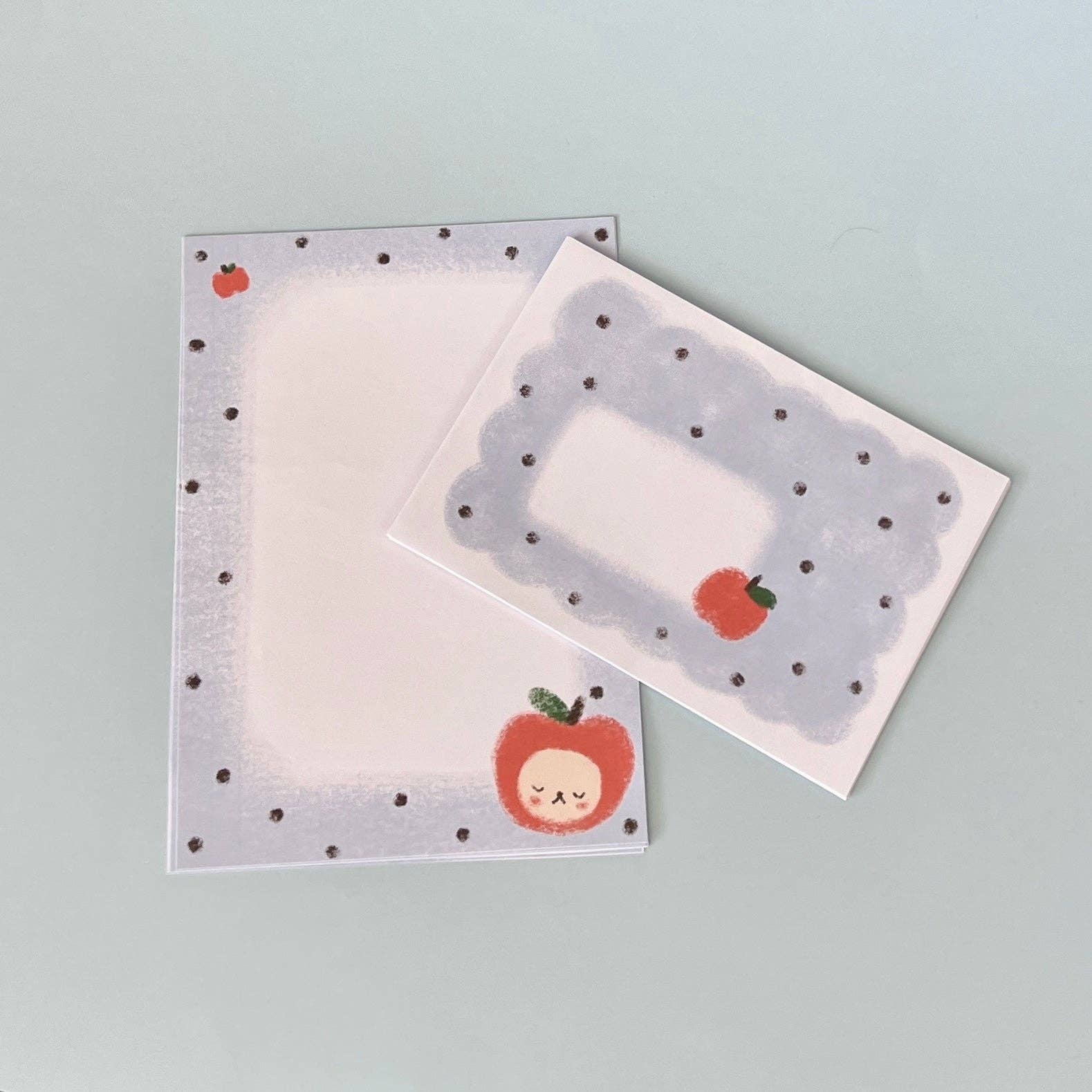 letter writing set with polka dot borders and apple designs on a light gray background