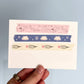 Set of decorative washi tape strips held by a hand on a light blue background