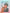 Person holding a cat with a pastel gradient background