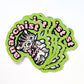 Stack of green stickers of a cat design with the text 'anarchist'