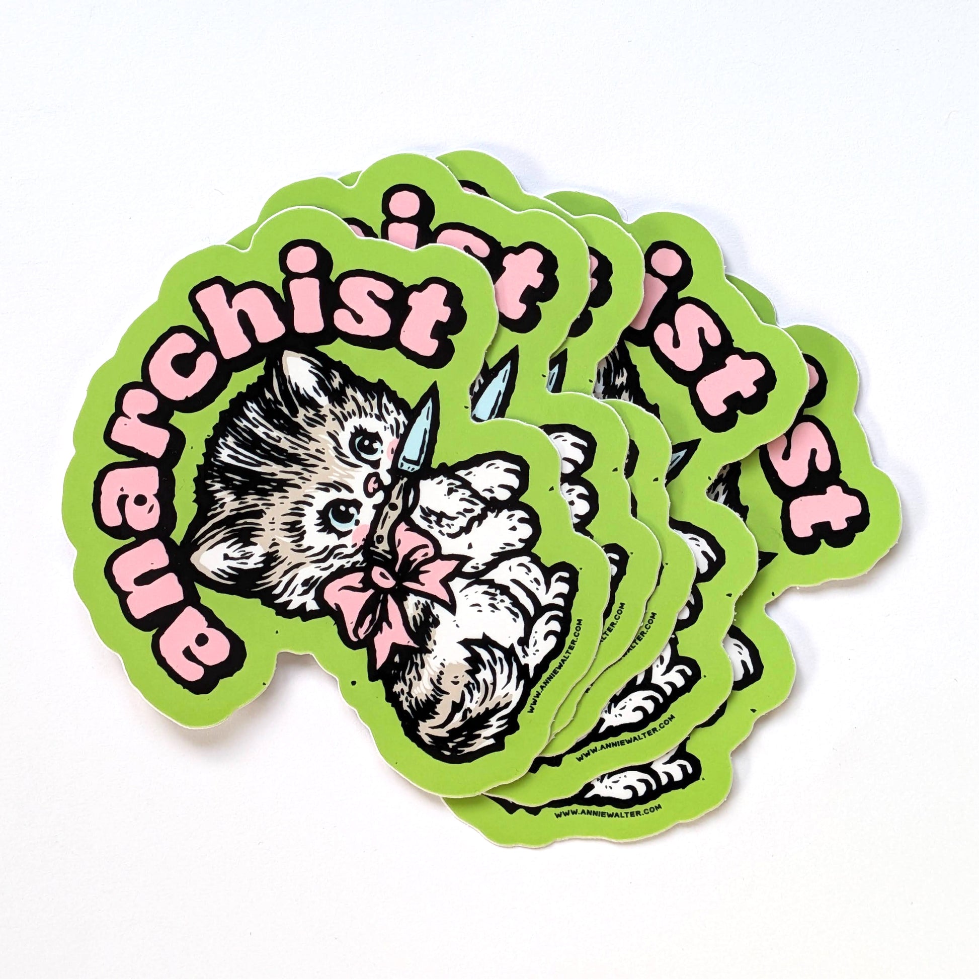 Stack of green stickers of a cat design with the text 'anarchist'