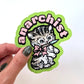 Hand holding a green sticker of a cat design with the text 'anarchist'
