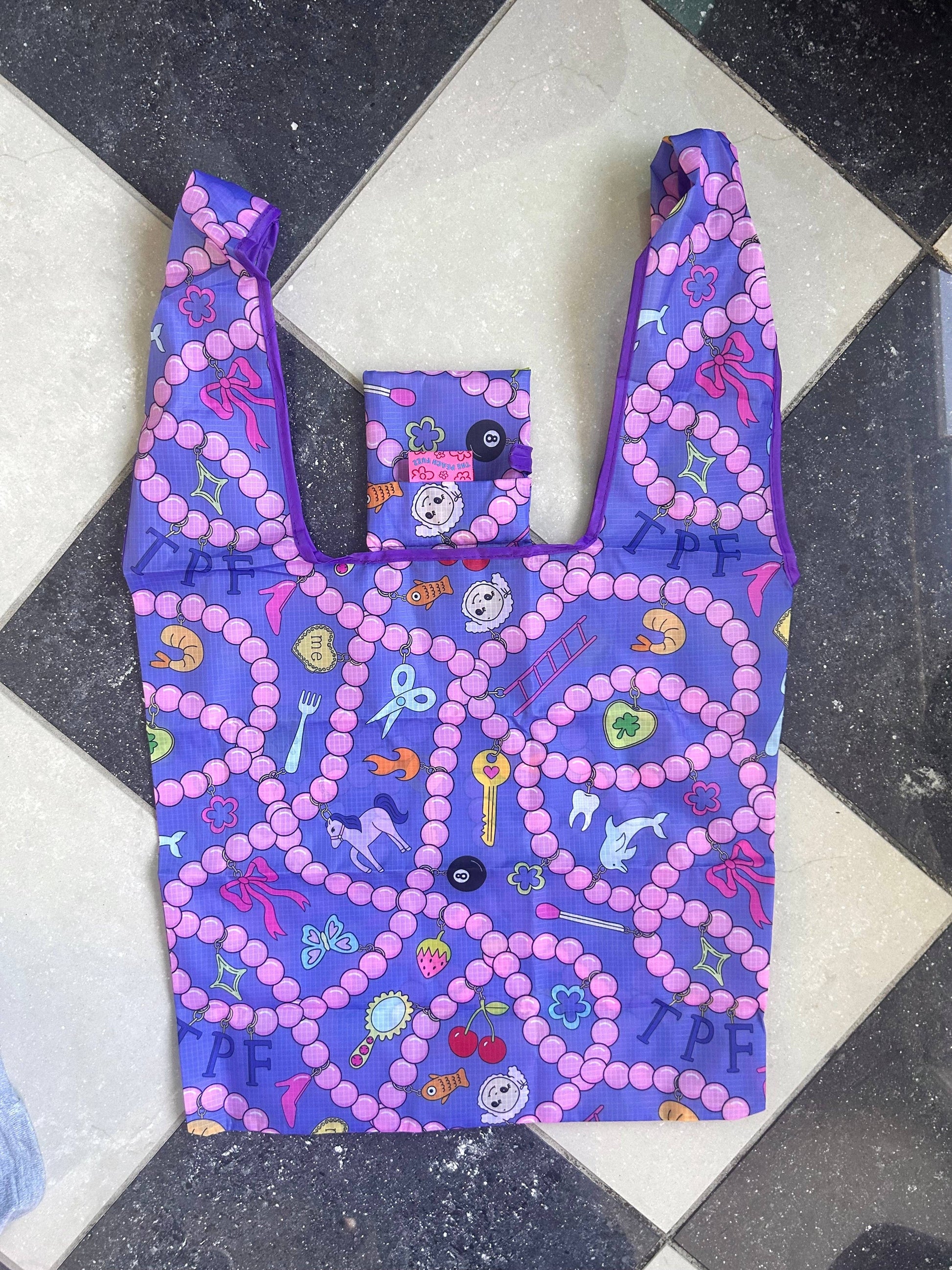 Reusable bag with colorful patterns on a black and white checkered floor