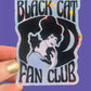 Sticker with 'Black Cat Fan Club' design held against a purple background