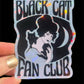 Holographic sticker with a woman and black cat design, labeled 'Black Cat Fan Club', held by a hand.