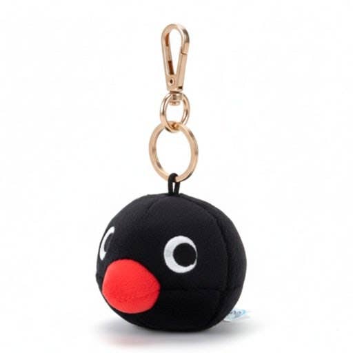 Black Pingu round keychain with a red nose and white eyes on a white background