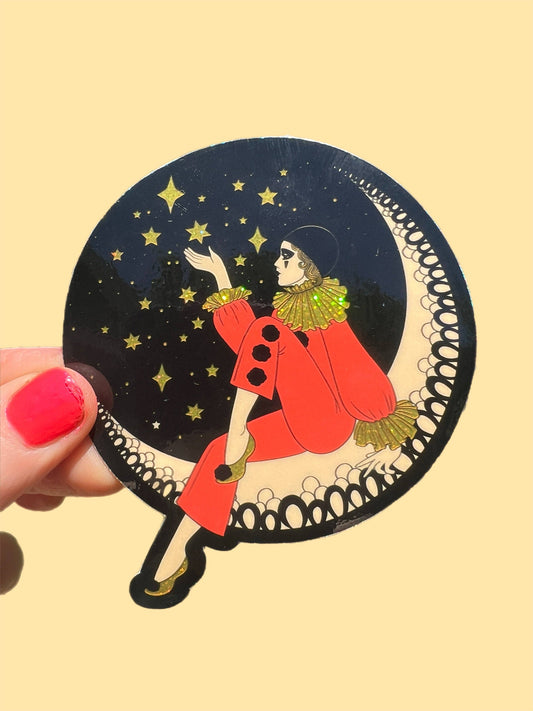 Decorative sticker of a person on a crescent moon with stars, held against a beige background.