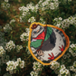 A die-cut sticker featuring a cartoon pigeon wearing a red bandana and green jacket, placed on a bed of small white flowers. The sticker has a yellow border and the text 'OOD OTOO' printed on the right side.