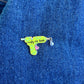 Colorful glue gun pin on a blue denim background