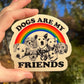 Sticker with dogs and rainbow design held by a hand outdoors