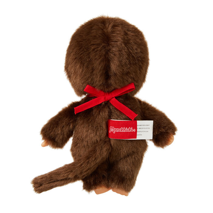 Brown plush toy with a red bow and visible brand label on a white background