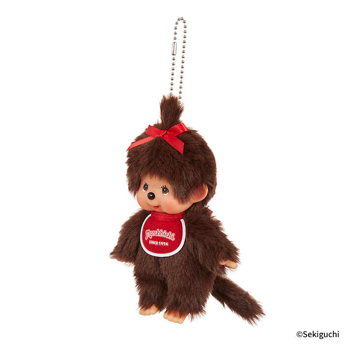 Plush Monchhichi keychain with a red bow and red bib on a white background, featuring the brand 'Sekiguchi'.