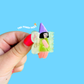 Hand holding a small fairy-themed product with a blue background