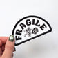 Patch with 'FRAGILE' text and a rose design held by a hand against a white background
