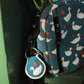 Small blue pouch with duck pattern and matching keychain on a green surface