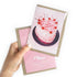 Hand holding a birthday card with a cake illustration and &