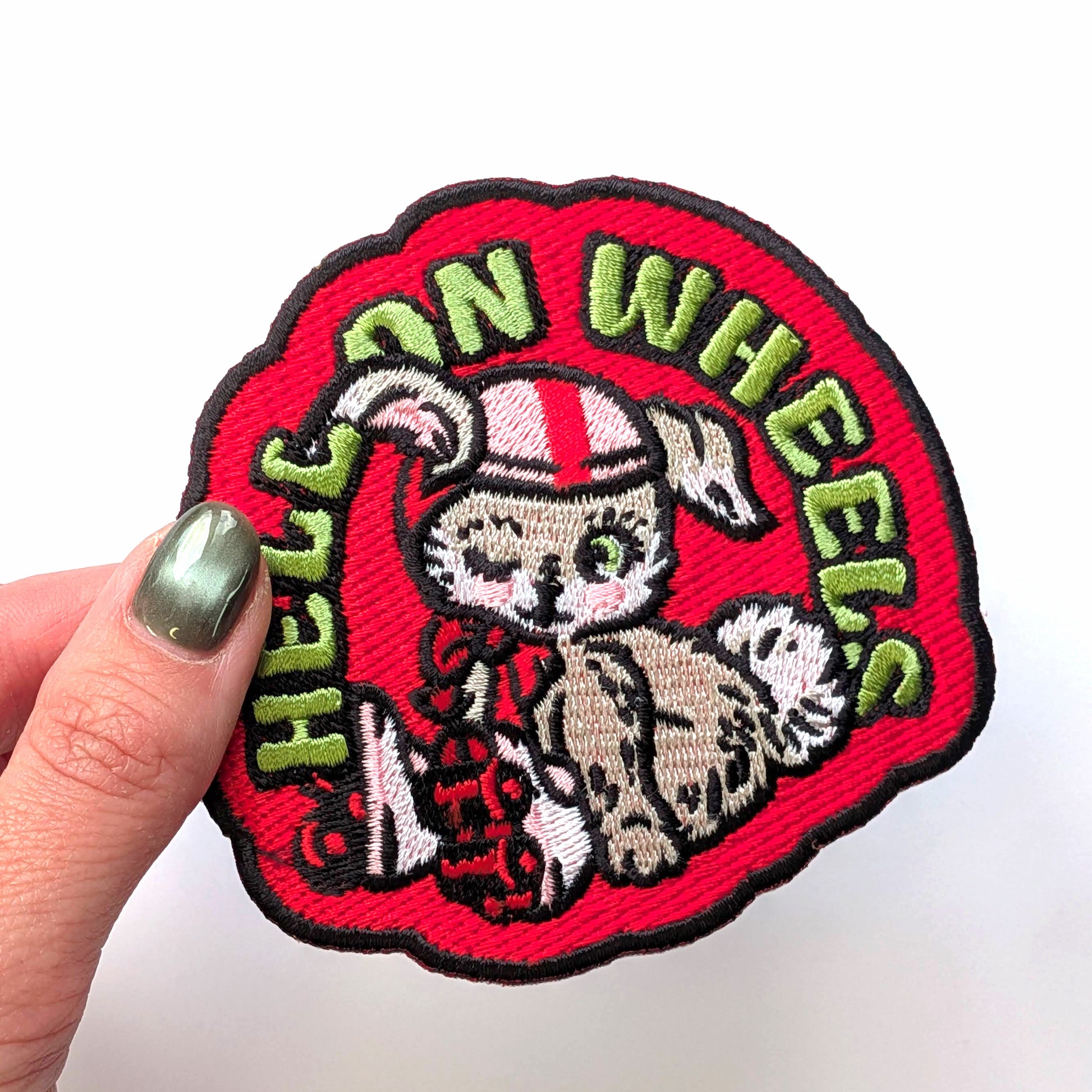 Embroidered patch with a bunny design and 'Hell on Wheels' text held by a hand.