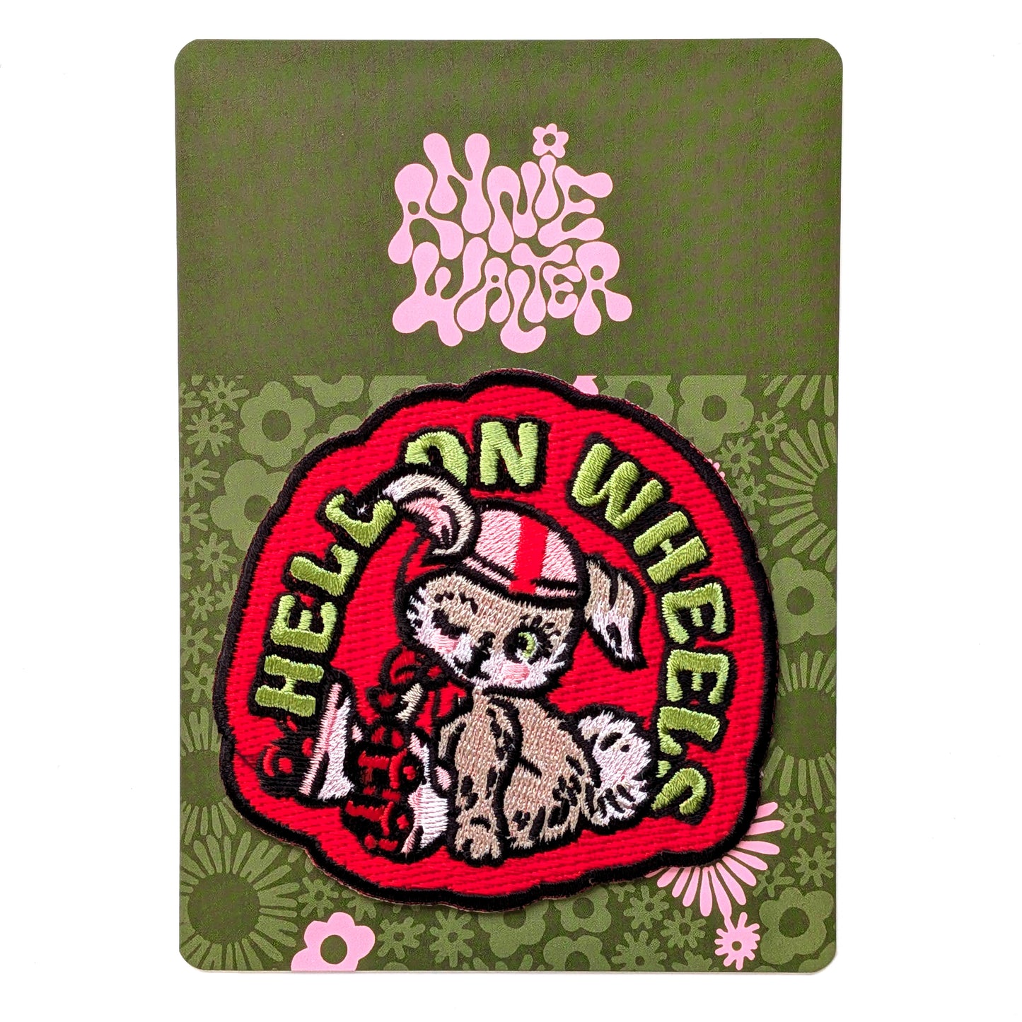 Embroidered patch with 'Hell on Wheels' design on a green card with floral patterns