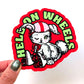 Sticker with a bunny on wheels design and 'HELL ON WHEELS' text held by a hand.
