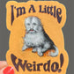 Sticker with a dog illustration and text 'I'm A Little Weirdo!' held by a hand.