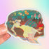 Sticker of a woman in a yellow dress with a colorful, artistic background held against a gradient background.
