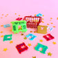 Colorful bread clips on a pink background with star decorations