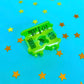 Green bread hair clip with text on a blue background with yellow stars