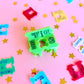 Colorful plastic bread clips on a pink background with star shapes