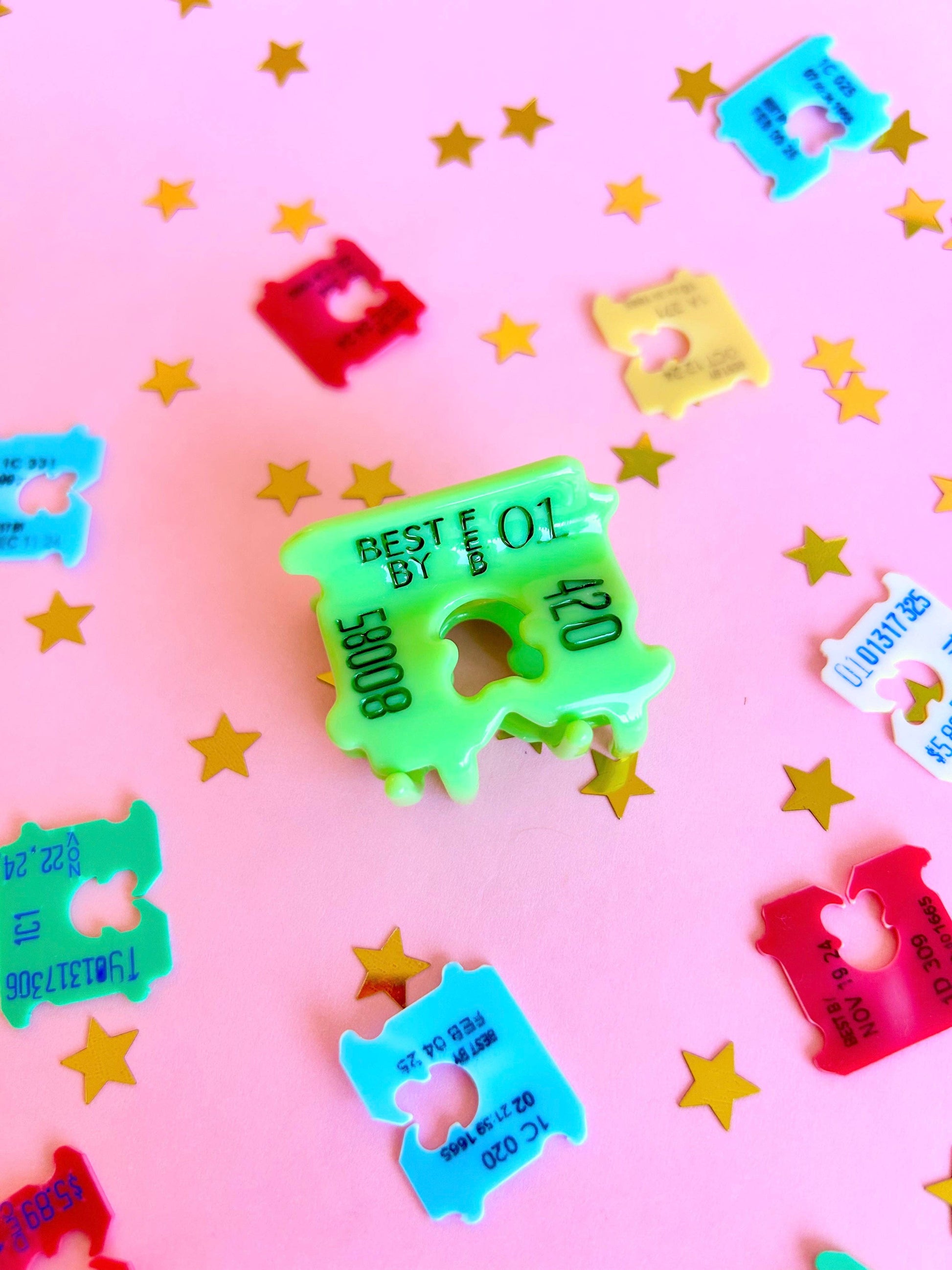 Colorful plastic bread clips on a pink background with star shapes