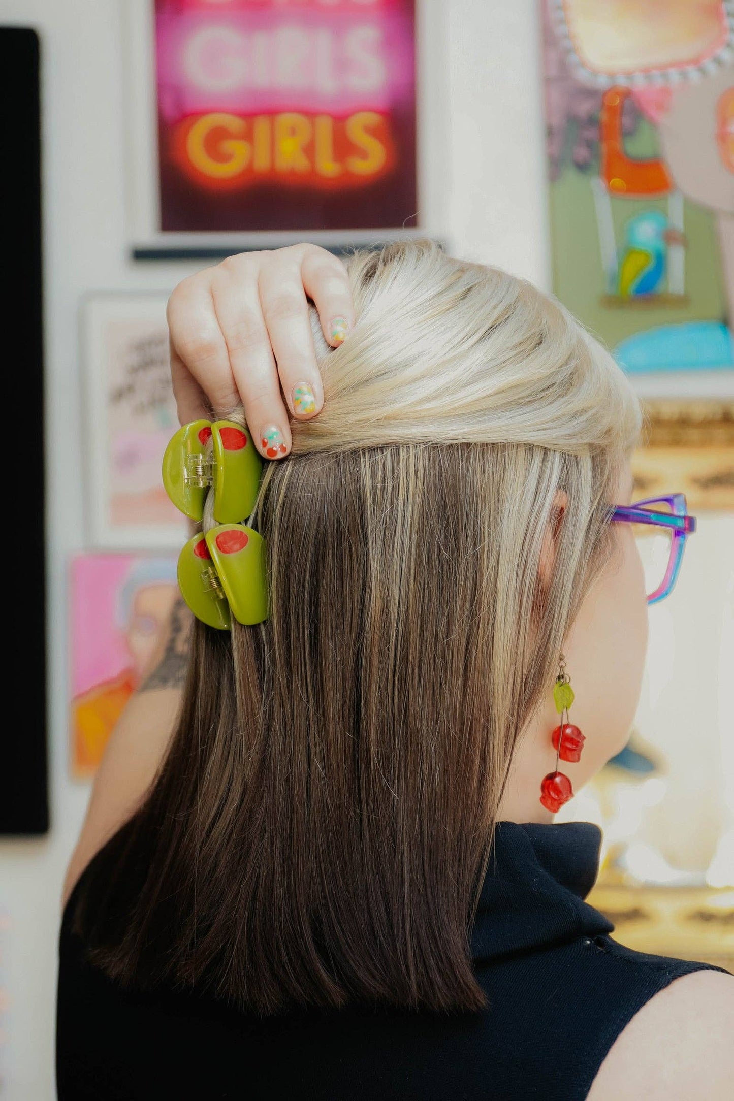 Person with blonde hair wearing two olive hair clips
