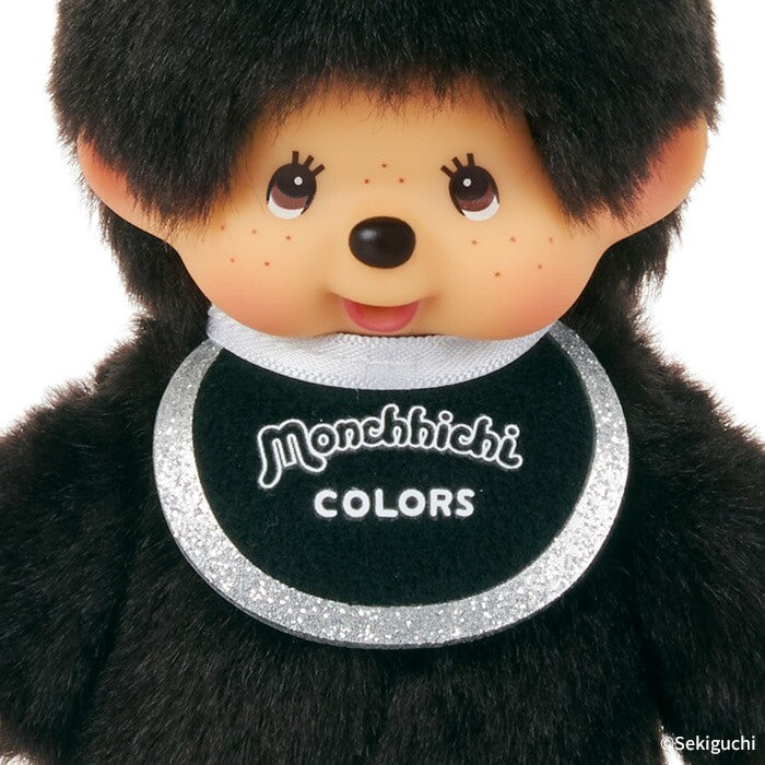 Plush toy with a black bib displaying 'Monchhichi Colors' on a white background
