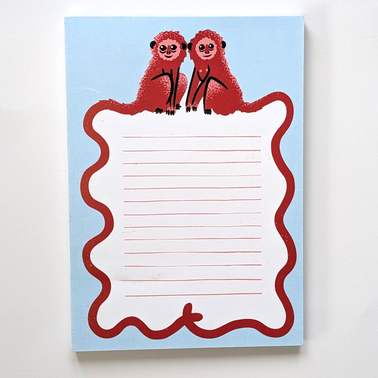 A blue notepad with monkey design on a white background