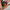 Circular decorative item with a person in an orange outfit and stars held in a hand.