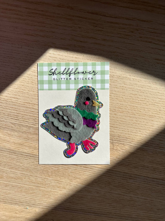 Shellflower glitter sticker on a checkered card with a wooden surface background