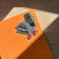 Pigeon glitter sticker on an orange surface