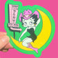 Sticker of betty boop on a moon with 'Pink Pony Club' sign, held against a pink background.