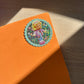 Orange notebook with a sticker of a polly pocket character on a wooden surface