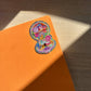 Colorful sticker on an orange notebook with a wooden surface background