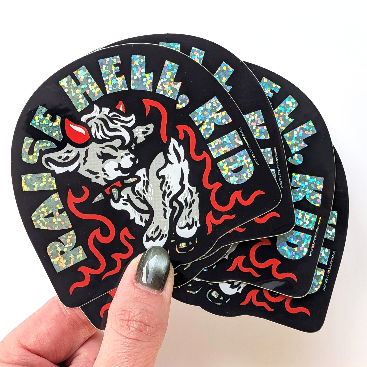 Stack of 'Raise Hell, Kid' stickers held by a hand with a white background
