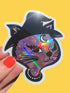 Holographic cat sticker held by a hand with red nail polish on a yellow background