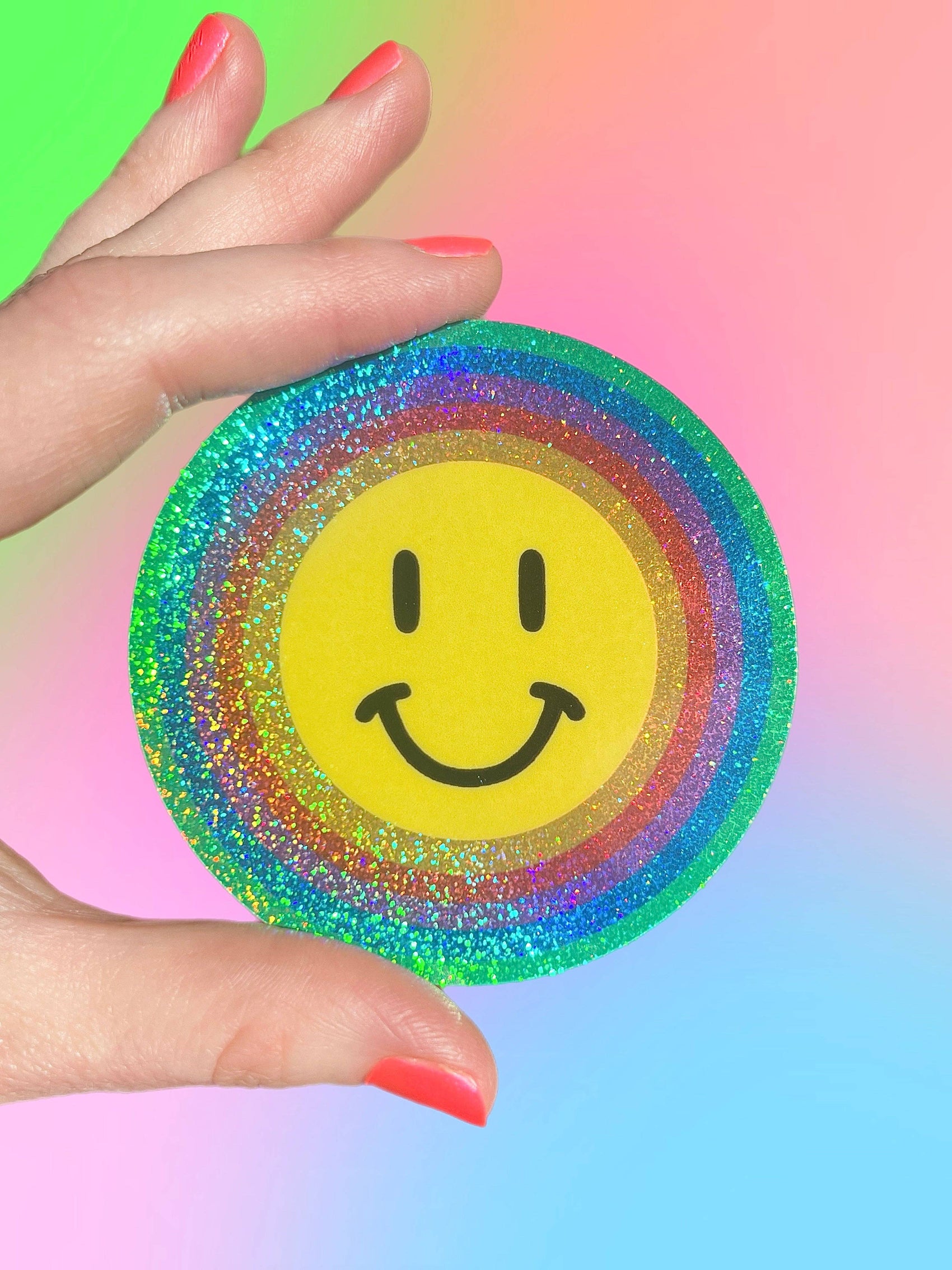 Hand holding a sicker with a smiley face on a gradient background