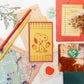 Collage of stationery items including a notepad with a dog illustration, pens, and stickers on a colorful background.