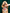 Dog wearing a checkered bandana with a heart design against a green curtain background
