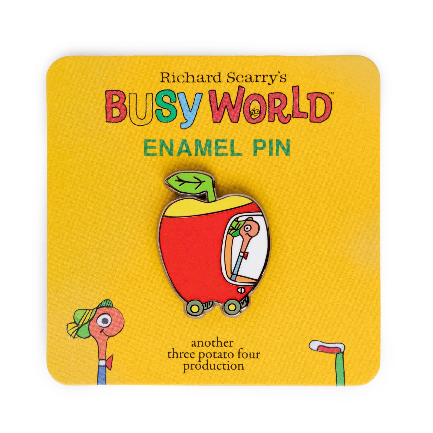 Enamel pin with cartoon character in an apple on a yellow card with 'Busy World' branding.