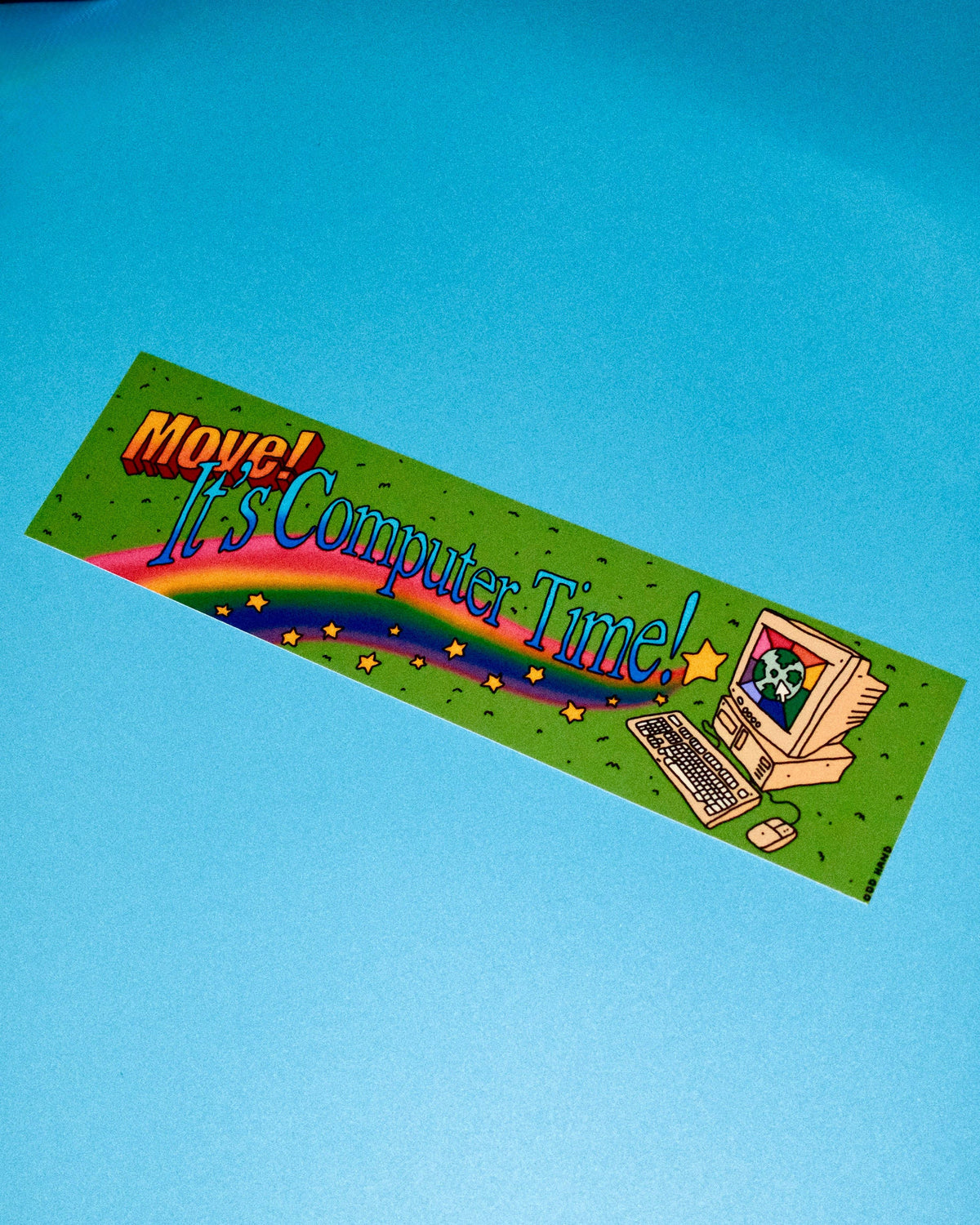 A rectangular green bumper sticker with the text 'Move! It's Computer Time!' in stylized lettering, featuring a cartoon computer, keyboard, mouse, rainbow, and stars, shown on a solid blue background.