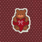Pixelated bear with red heart and bow on a patterned background