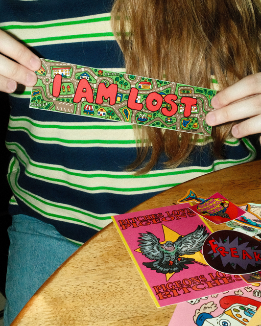 Person holding a colorful 'I AM LOST' sticker