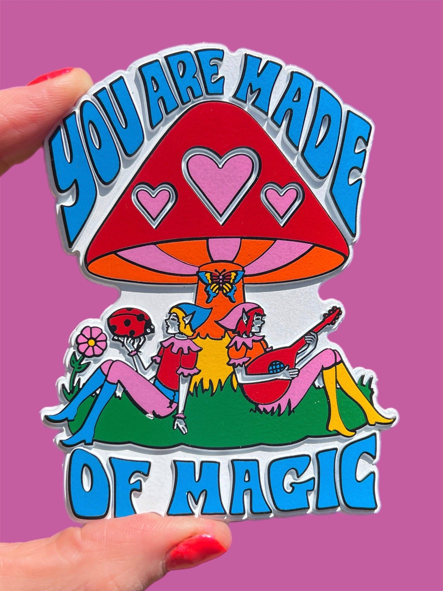 Magnet with colorful design of people under a mushroom and 'You are made of magic' text on a pink background.